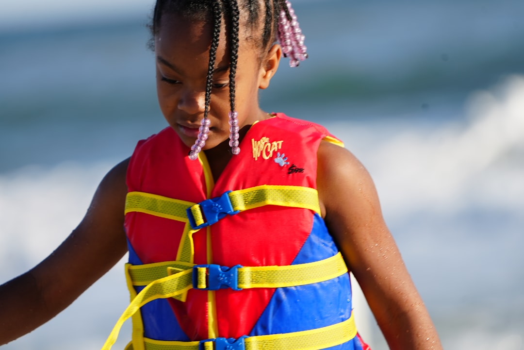 Florida boating license age requirements - young boater steering boat wearing life vest